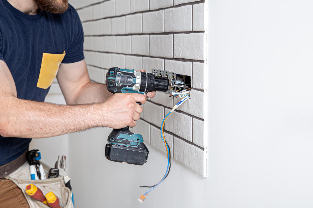 Électricien en rénovation sur une installation électrique ancienne